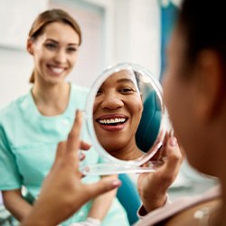 Patient smiling at reflection in treatment chair