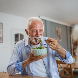 Man smiling while eating lunch at home
