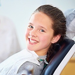 Smiling young girl in dental chair