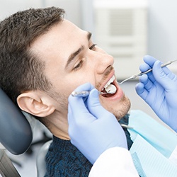 Man receiving dental exam from Sweeny emergency dentist