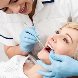 Woman preventing dental emergencies in Sweeny by visiting her dentist