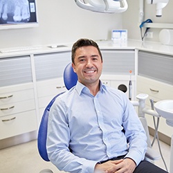 Man in collared shirt smiling in dental chair