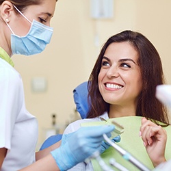 A middle-aged woman talking to her dentist about dental implant placement during a consultation