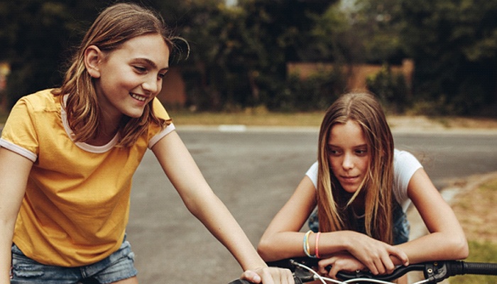 teenage friends smiling and riding their bikes together