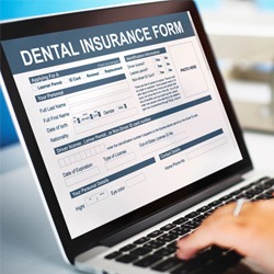 Patient filling out dental insurance form on computer