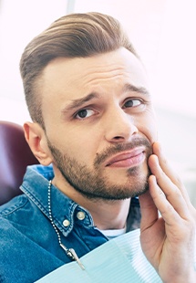 man holding his cheek in pain