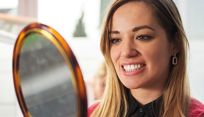 Woman looking at smile in mirror