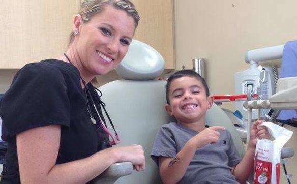 Team member with young boy in dental chair
