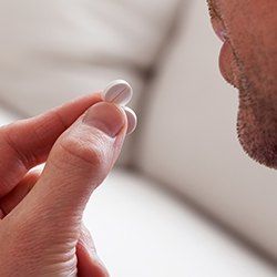 Closeup of patient taking oral sedative pill