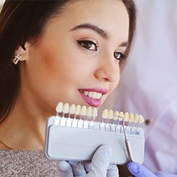 Woman's smile compared with tooth color chart