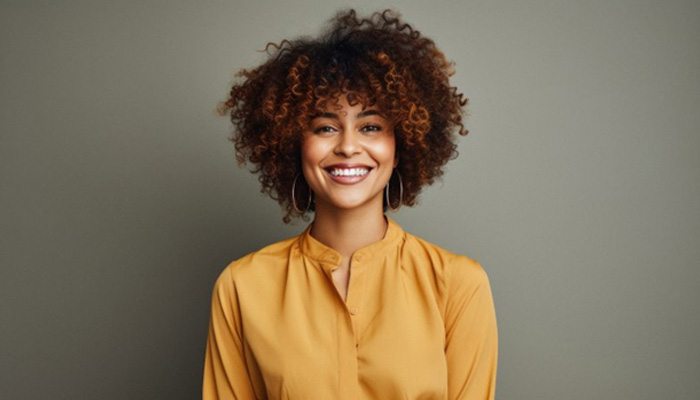 Woman with curly hair smiling in neon green shirt