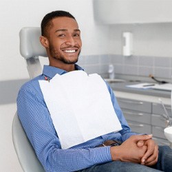 Male dental patient smiling with hands folded
