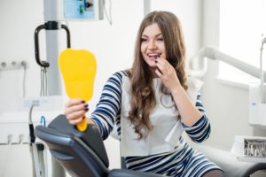 Woman at dentist looking in mirror