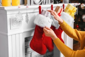 person putting stocking stuffers in stockings