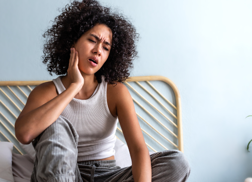 Woman holding jaw in pain