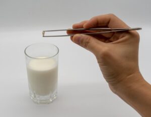 Parent putting their child’s tooth in milk